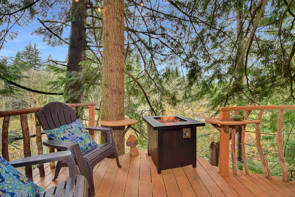 The North Bend treehouse on many Airbnb wishlists includes a wraparound deck with a propane fire pit, Adirondack chairs and more.