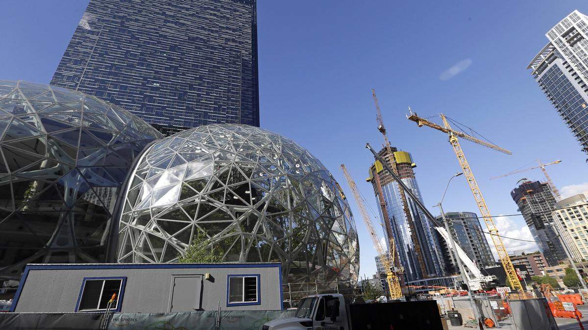 In this Oct. 11, 2017 photo, large spheres take shape in front of an existing Amazon building, behind, as new construction continues across the street in Seattle. Amazon recently announced its choices for expanded headquarters locations.