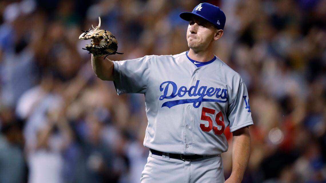 Los Angeles Dodgers relief pitcher Zac Rosscup calls for a new ball after giving up a two-run home run to Colorado Rockies’ Ryan McMahon during the seventh inning of a baseball game Friday, Aug. 10, 2018, in Denver. (AP Photo/David Zalubowski)