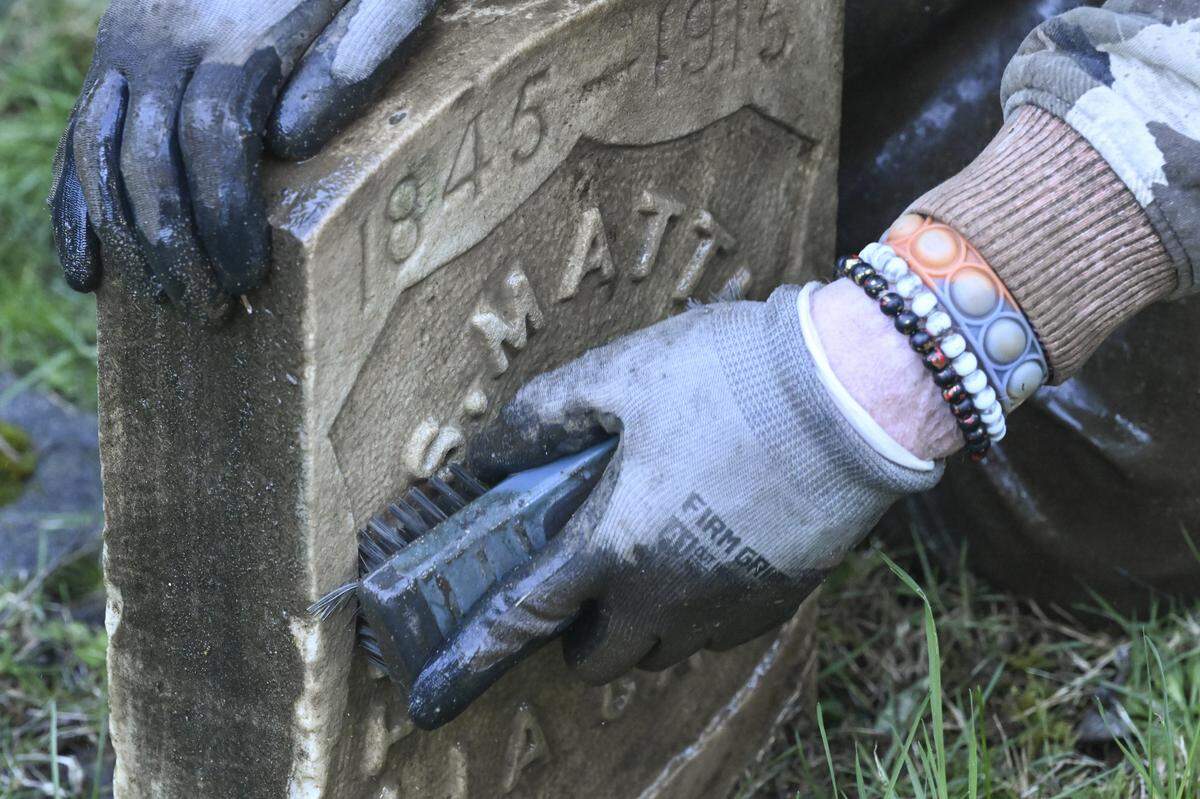William Fleet scrubs a headstone at the old Tacoma Cemetery on Monday, March 9, 2026, in Tacoma, Wash.