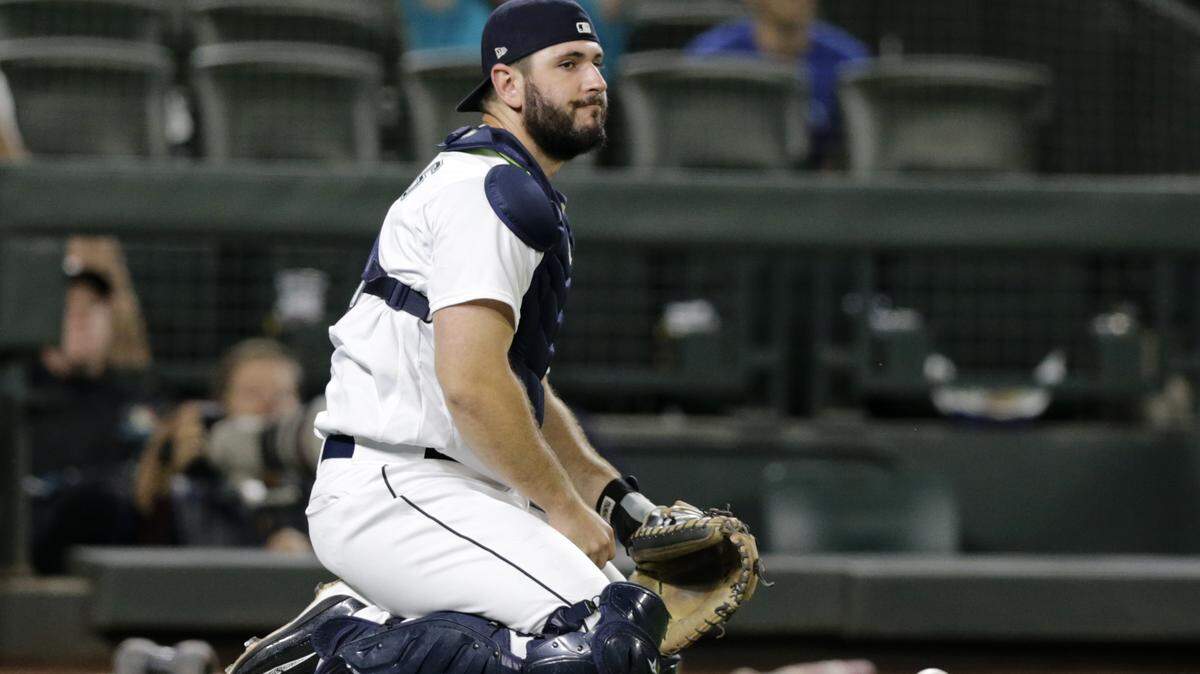 Seattle Mariners catcher David Freitas kneels on the field after dropping a pop foul ball by Baltimore Orioles’ Cedric Mullins during the eighth inning of a baseball game Tuesday, Sept. 4, 2018, in Seattle. (AP Photo/John Froschauer)