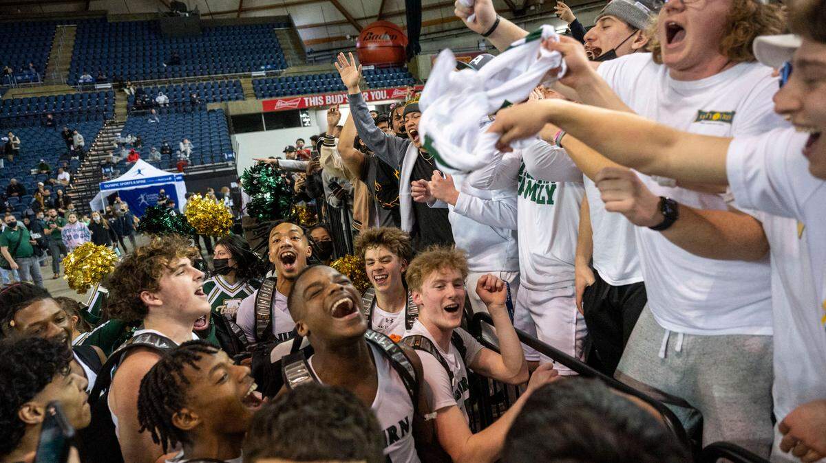 Auburn players celebrate with the student section after beating Seattle Prep, 45-34, in a Class 3A semifinal state tournament game on Friday, March 4, 2022, at the Tacoma Dome, in Tacoma, Wash.