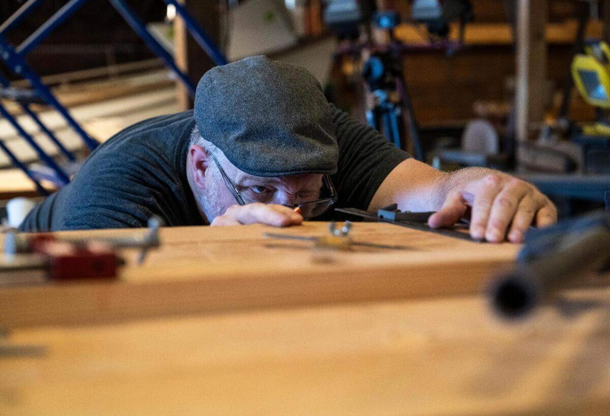 Jonathan Cunningham works on a Croatian fishing boat that is being built as part of “The Batana Project” at the Gig Harbor Boat Shop in Gig Harbor, Wash. on Wednesday, July 20, 2022. Once the boat is complete, the boat shop will host an event to reveal it Sept. 3.