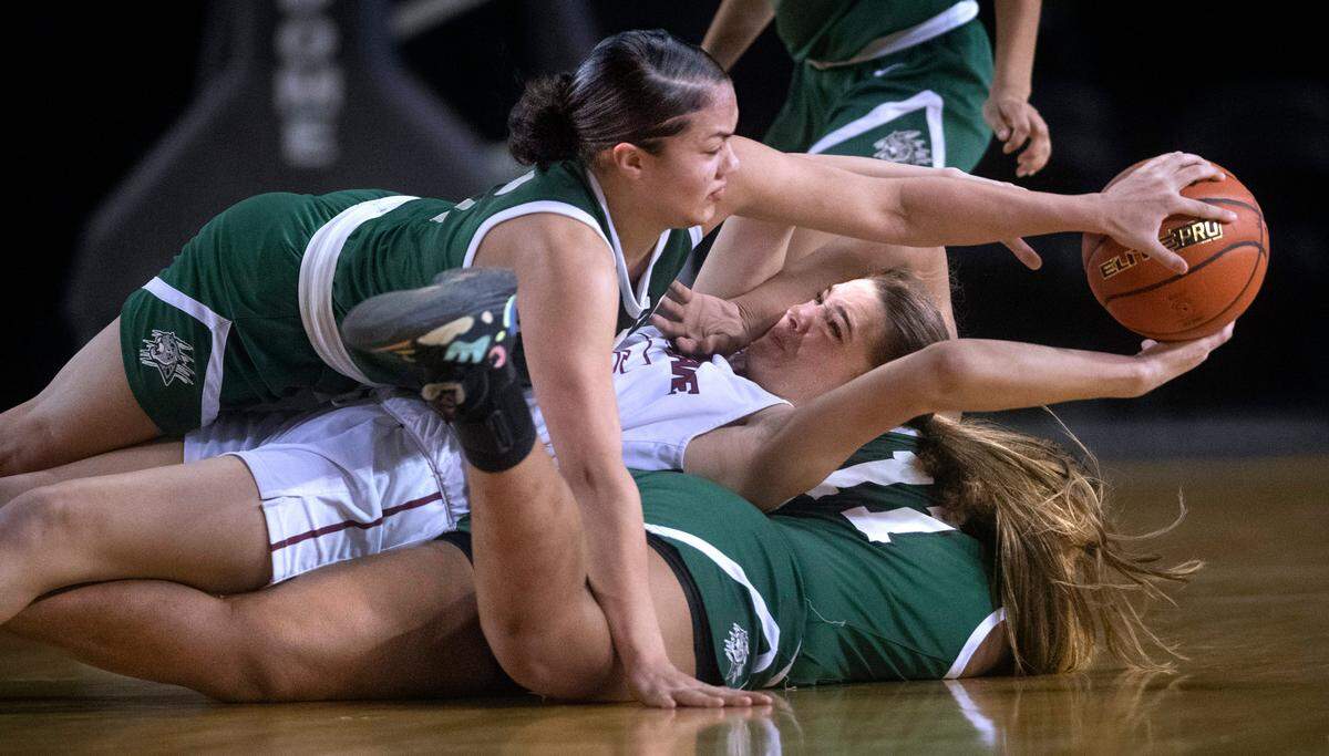 Emerald Ridge’s Monique Carter (top) and Marecia Barnett swarm Eastlake’s Sophia Aluas to force a turnover during Thursday morning’s quarterfinal game of the WIAA 3A Girls Basketball State Championships tournament in the Tacoma Dome in Tacoma, Washington, on Thursday, March 3, 2022. After rallying from 13 point deficit, Emerald Ridge took the lead before falling, 44-43.