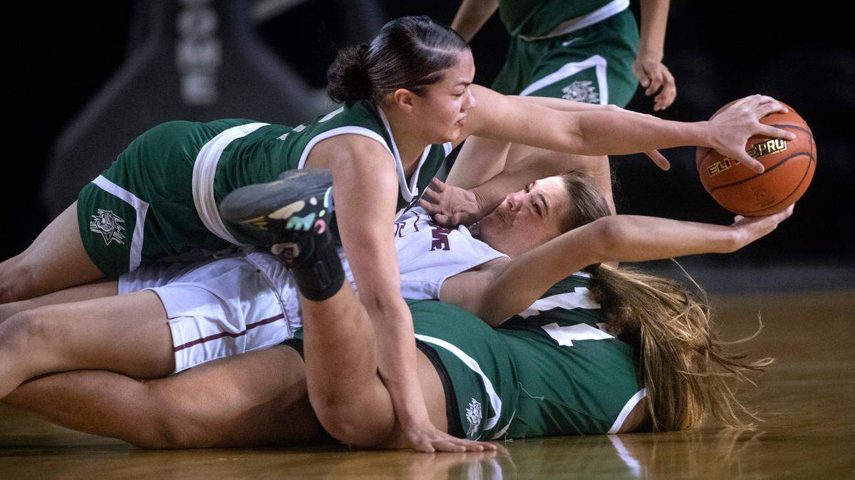 Emerald Ridge’s Monique Carter (top) and Marecia Barnett swarm Eastlake’s Sophia Aluas to force a turnover during Thursday morning’s quarterfinal game of the WIAA 3A Girls Basketball State Championships tournament in the Tacoma Dome in Tacoma, Washington, on Thursday, March 3, 2022. After rallying from 13 point deficit, Emerald Ridge took the lead before falling, 44-43.
