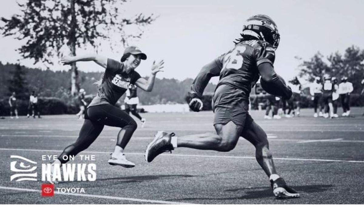Canadian Amanda Ruller, Seahawks assistant coach on the Bill Walsh NFL Minority Coaching Fellowship, runs at running back Darwin Thompson during drills at Seattle’s minicamp in June, 2022.