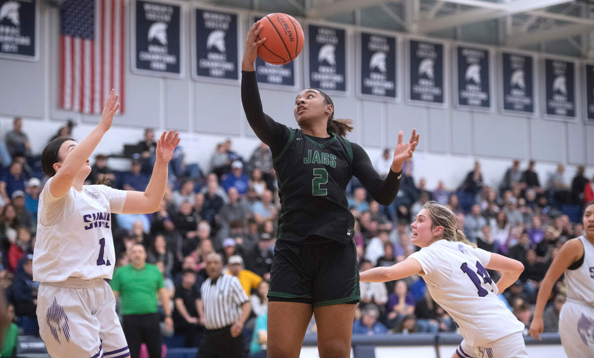 Emerald Ridge’s Ryah McGriff (2) spins to the basket between Sumner defenders Kylie Griffin (left) and Mattie Gillaspy during Saturday night’s 4A SPSL girls basketball tournament championship game at Tacoma Community College in Tacoma, Washington, on Feb. 4, 2023. Sumner held off a late Emerald Ridge rally to win the game, 50-48.