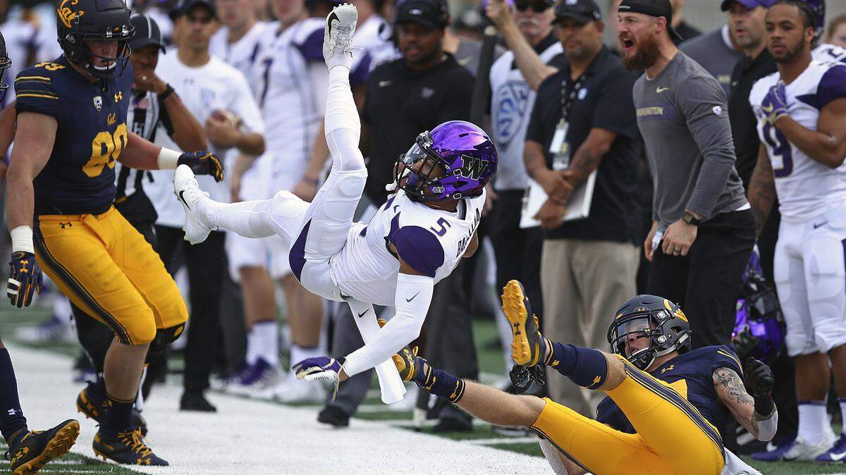 Washington’s Andre Baccellia (5) is upended by California’s Ashtyn Davis, right, during the first half of an NCAA college football game Saturday, Oct. 27, 2018, in Berkeley, Calif. (AP Photo/Ben Margot)