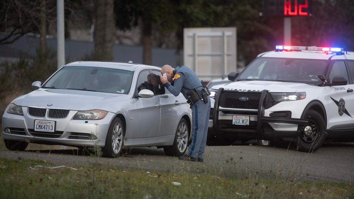 A Washington State Patrol trooper checks on an vehicle left unattended along Interstate 5 in Lakewood, Washington, on Thursday, Dec. 19, 2024.
