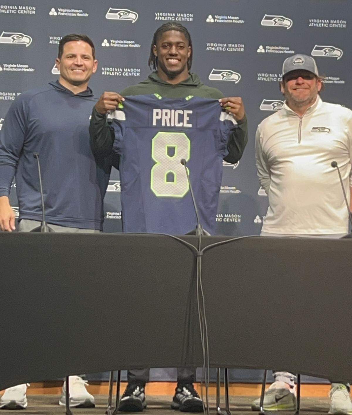 Coach Mike Macdonald (left), rookie running back and NFL draft first-round pick Jadarian Price (center) and general manager John Schneider (right) on Price’s first day with the Seahawks Thursday, April 30, 2026, at the team’s Virginia Mason Athletic Center in Renton.