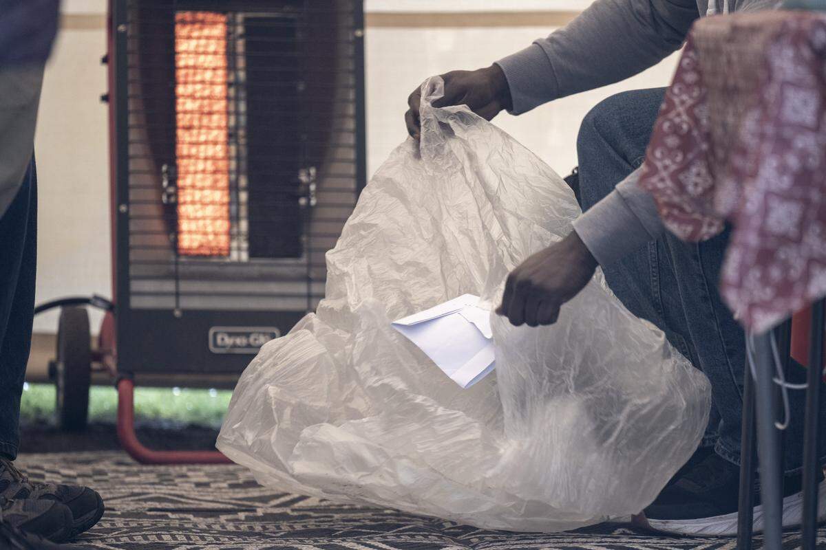 A released ICE detainee moves their belongings from a thin plastic bag to a backpack provided to them at the welcome center run by Advocates for Immigrants in Detention Northwest on Friday, March 20, 2026, outside of the Northwest ICE Processing Center in Tacoma, Wash.