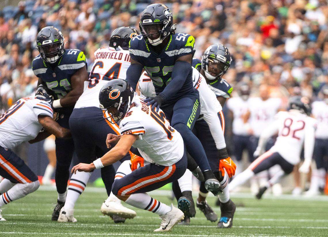 Seattle Seahawks defensive end Darrell Taylor (52) tackles Chicago Bears quarterback Trevor Simian (15) during the first half of the Seahawks second preseason game at Lumen Field in Seattle, Wash. on August 18, 2022.