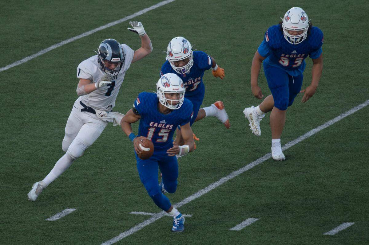 Graham-Kapowsin High School quarterback Daveon Superales (15) scrambles for a short gain in the first quarter. The Eagles played Rogers in a 4A SPSL football game on Thursday, Sept. 1 at Art Crate Field in Spanaway, Wash.