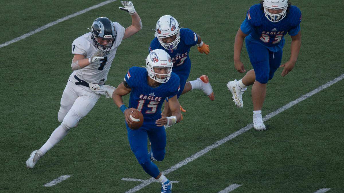 Graham-Kapowsin High School quarterback Daveon Superales (15) scrambles for a short gain in the first quarter. The Eagles played Rogers in a 4A SPSL football game on Thursday, Sept. 1 at Art Crate Field in Spanaway, Wash.