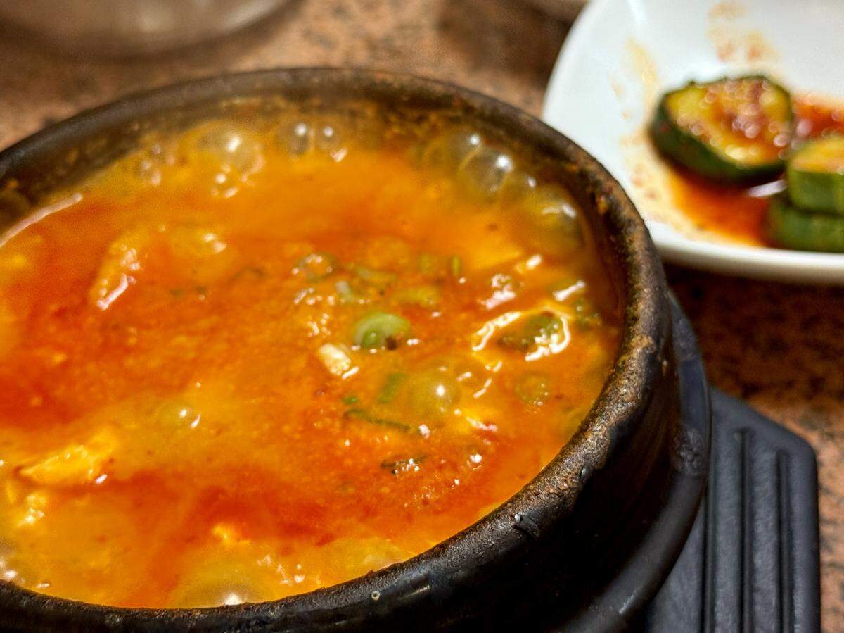 Cho Dang Tofu stands out in a sea of Korean restaurants, where sundubu sizzles (here shown with dumplings) alongside KBBQ and bibimbap.