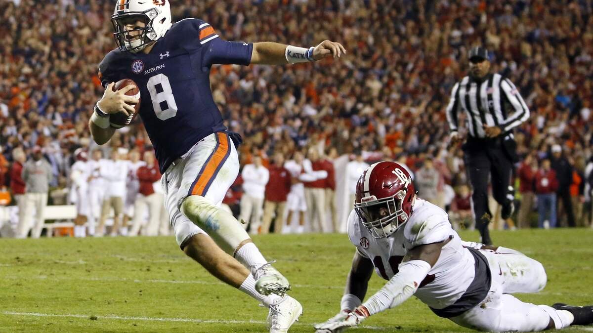 FILE-In this Nov. 25, 2017, file photo, Auburn quarterback Jarrett Stidham (8) gets past Alabama linebacker Dylan Moses (18) to carry the ball in for a touchdown during the second half of the Iron Bowl NCAA college football game, in Auburn, Ala. Auburn has high hopes for Stidham, who was one of the SEC’s most efficient passers as a first-year starter. Auburn hasn’t had a two-year starter at quarterback since Nick Marshall in 2013 and 2014.  (AP Photo/Butch Dill, File)