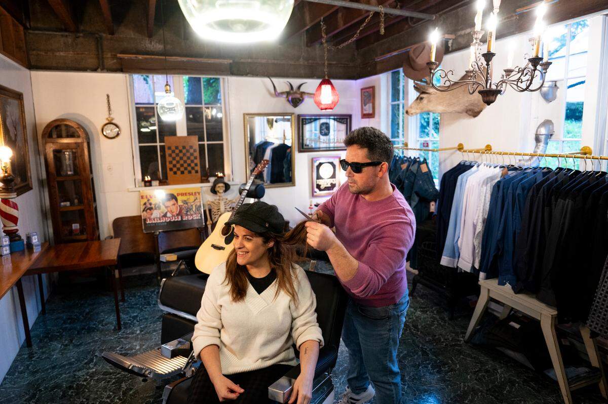 Co-owners Starr Hall and her boyfriend, Bruce Hillenbach pose for portrait at One:11 speakeasy barbershop behind the gentlemen’s store, on Wednesday, Jan. 10, 2024, in Gig Harbor, Washington.