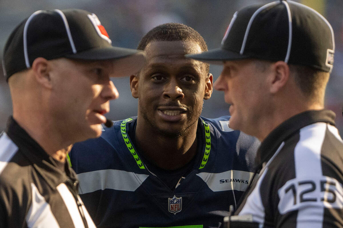 Seattle Seahawks quarterback Geno Smith (7) looks on as a pair of referees discuss a penalty during an NFL game against the Arizona Cardinals on Sunday, Oct. 16, 2022, at Lumen Field in Seattle.