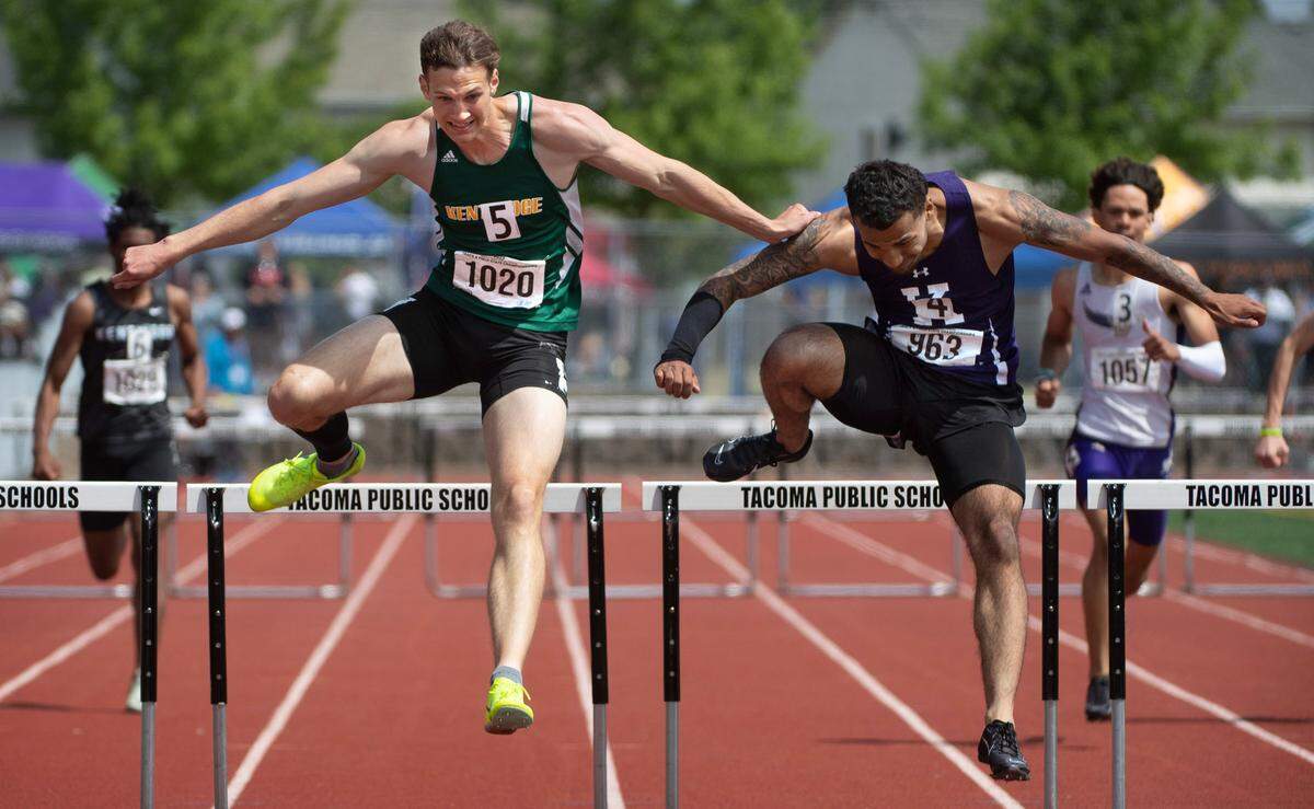 Kentridge’s Alex Conner battles Kamiak’s Jaquan Means over the final hurdle before both runners collapsed over the finish line during the final day of the WIAA state track and field championships at Mount Tahoma High School in Tacoma, Washington, on Friday, May 26, 2023. Conner took the state title by .01 second.