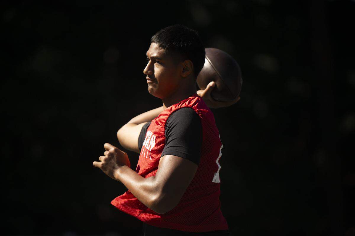 Lincoln quarterback Sione Kaho warms up during a football practice at Lincoln High School on Wednesday, Aug. 20, 2025, in Tacoma, Wash..
