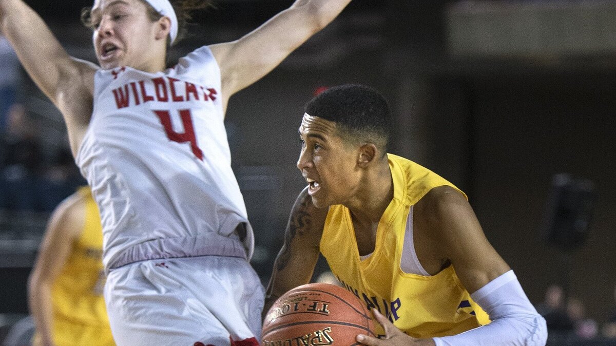 Puyallup’s Jaeden Ingram bowls over Mount Si defender Bennett O’Connor during their WIAA Hardwood Classic 4A boys state basketball tournament quarerfinal in the Tacoma Dome on Thursday, Feb. 28, 2019.