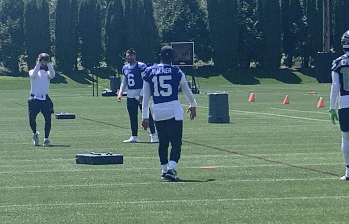 Seahawks backup quarterbacks Sam Howell (6) and P.J. Walker (15) warm up before a practice at Seahawks offseason minicamp June 11, 2024, at the Virginia Mason Athletic Center in Renton.