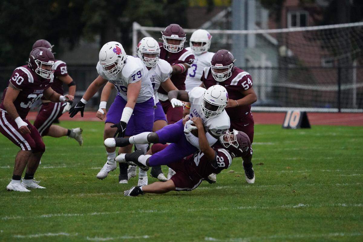 Lily Godwin, number 28, makes a solo tackle for the University of Puget Sound Loggers on Peyton Field at Baker Stadium on Saturday, Oct. 21, 2023. Godwin is believed to be the first female football player in NCAA history to make a solo tackle.