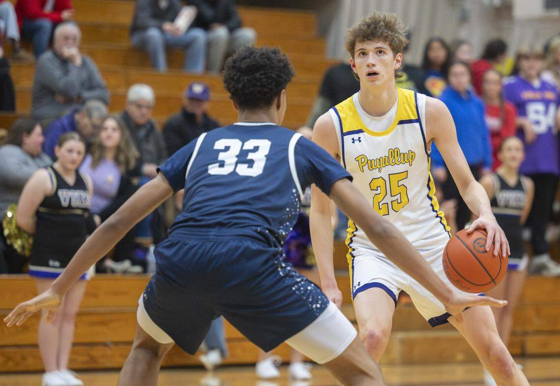 Puyallup senior Will Nasinec (25) eyes the net while being guarded by Olympia sophomore Elijah Lewis (33) on Thursday, Jan. 15, 2026, in Puyallup, Wash.