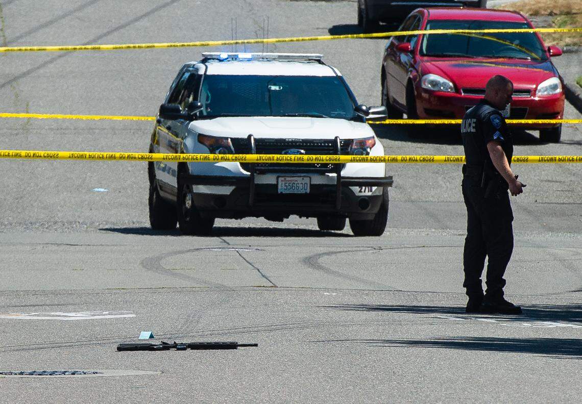 A rifle lies in the road as police investigate the scene of an officer-involved shooting at South 40th and South G streets in Tacoma on July 21, 2019. A Tacoma police officer shot a man after a traffic stop after the man aimed a rifle at the officer. The man was taken to a local hospital with life-threatening injuries and later died, according to police.