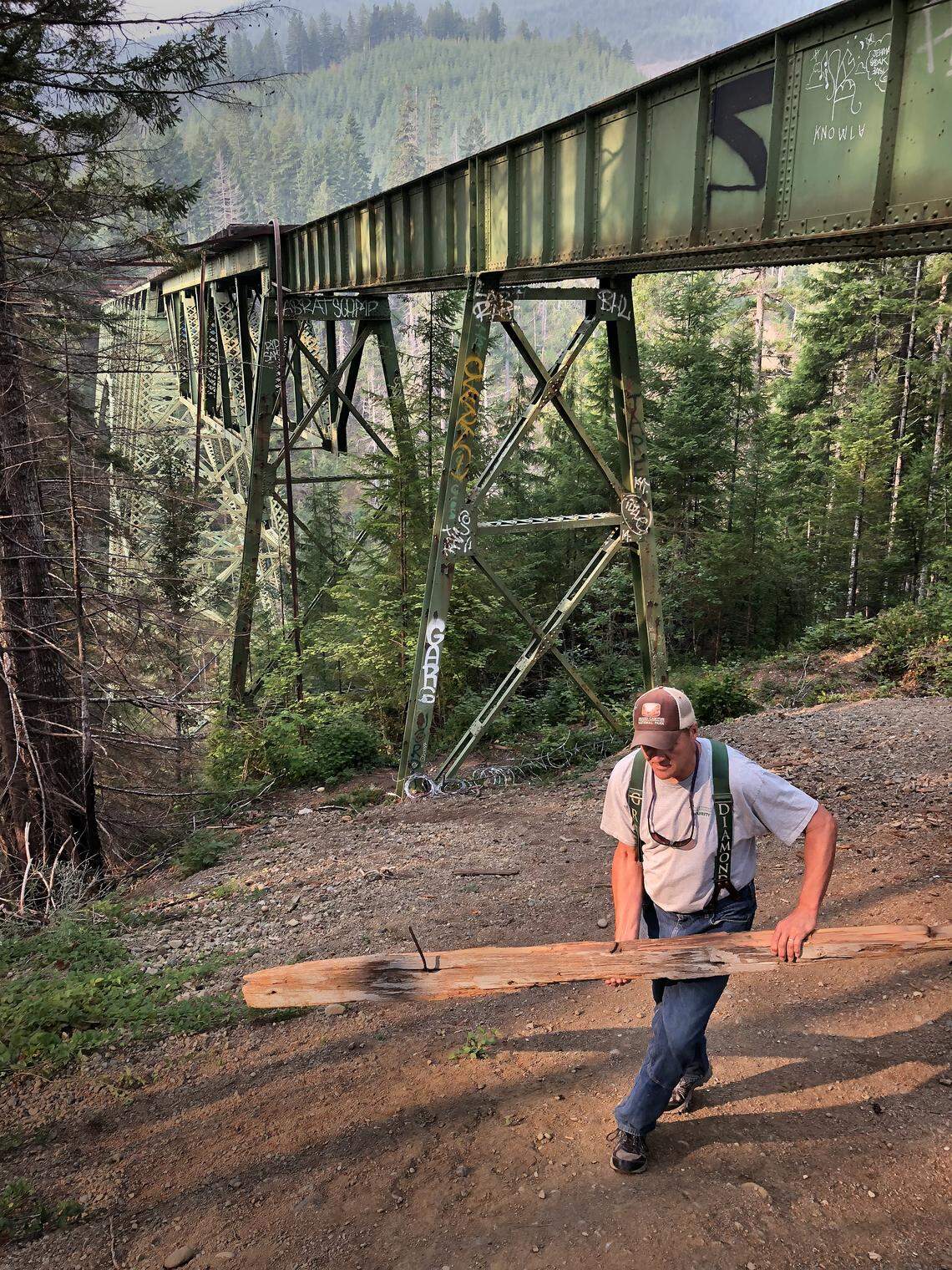 Matt Nixon of Green Diamond Resource Company hauls away lumber used by people to climb up a support for the Vance Creek Bridge. It’s a constant battle to keep people from climbing onto the dangerous bridge, he said.