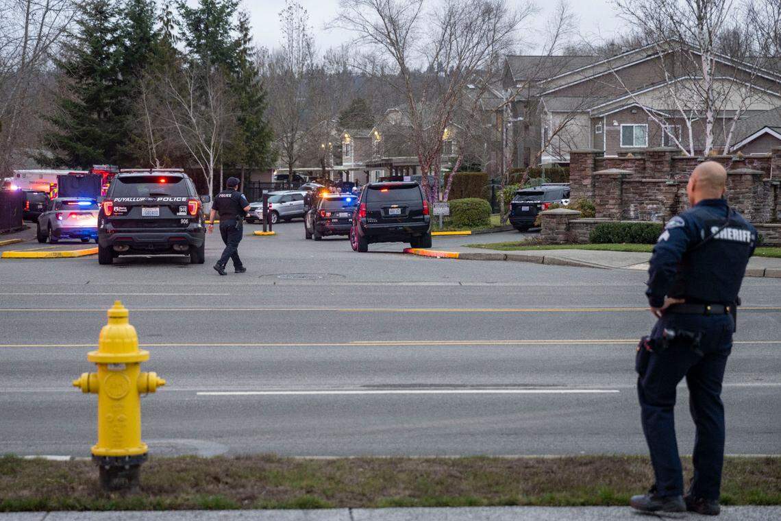 Sgt. Darren Moss from the Pierce County Sheriff’s Department stands along East Main Avenue in Puyallup as law enforcement officers from multiple agencies managed the scene of a standoff with a domestic-violence suspect at an apartment complex on Tuesday, Jan. 24, 2023.