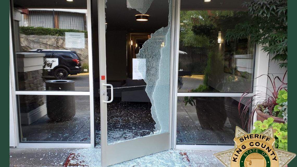 In this photo, a shattered doors are shown at a Woodinville, Washington, apartment complex on Sept. 13, 2021. Officials said a man threw a rock through the doors and damaged the exit signs inside the building after a fight with his girlfriend.