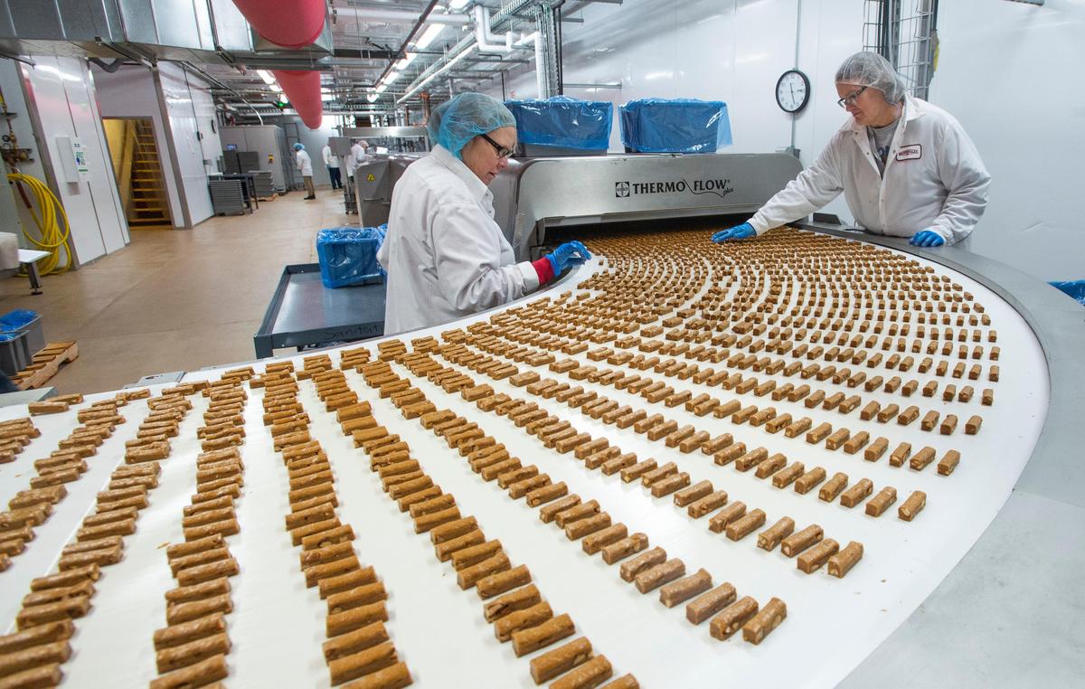Brown & Haley employees Margaret Castro, left, and Peggy Bruce check for misshapen toffee logs prior to getting a coating of chocolate and almonds. The venerable Tacoma candy maker was offering tours of its new state-of-the-art Almond Roca production line on Tuesday, Oct. 22, 2019.