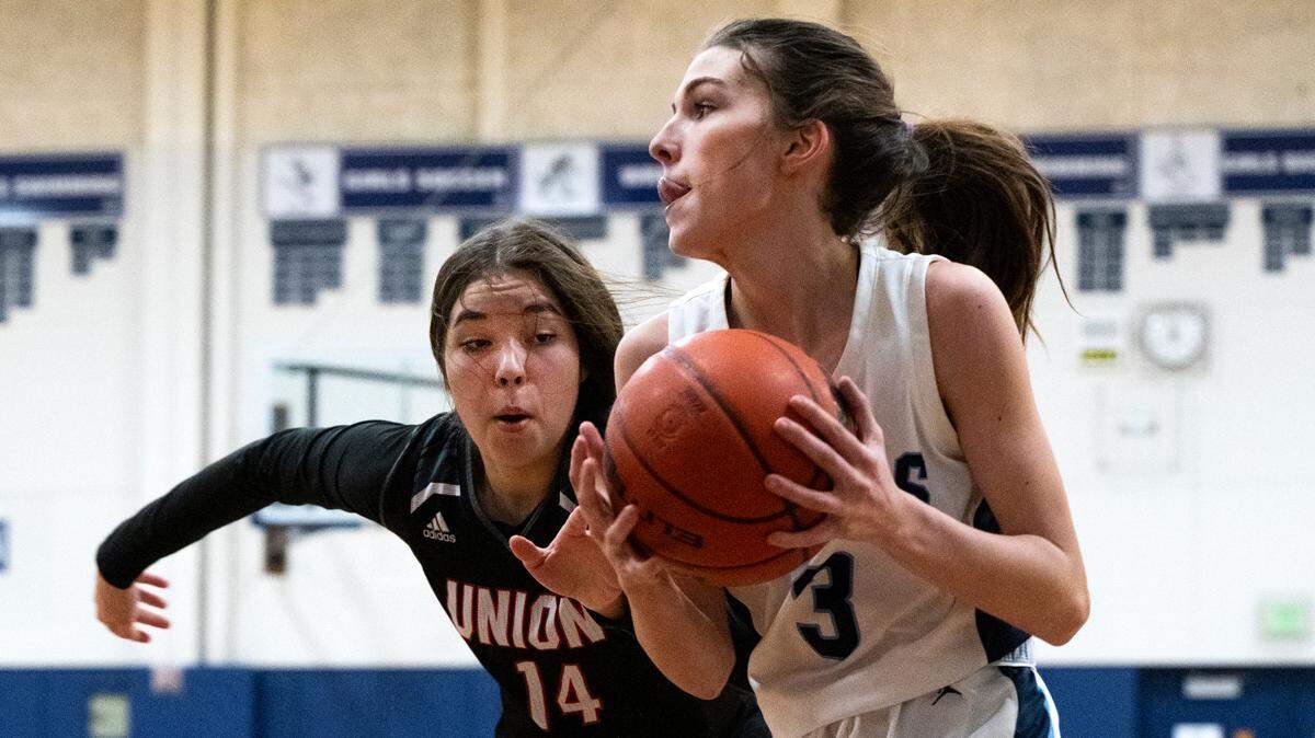 Olympia guard Lauren Wolin (3) drives to the basket as Union forward Hanna Summers (14) defends during a West Central III/Southwest bi-district tournament girls basketball opening-round game on Friday, Feb. 11, 2022, at Olympia High School in Olympia, Wash.