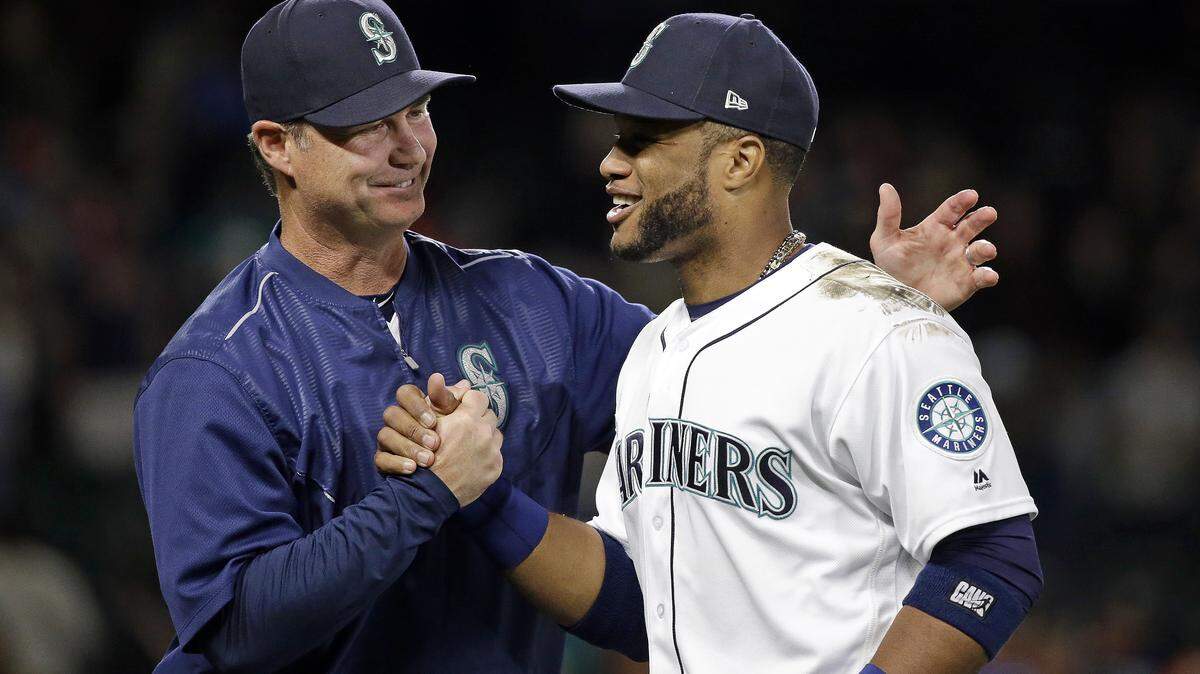 Seattle Mariners manager Scott Servais, left, greets Robinson Cano after the Mariners defeated the Detroit Tigers 9-6 in a baseball game Thursday, June 22, 2017, in Seattle. (AP Photo/Elaine Thompson)