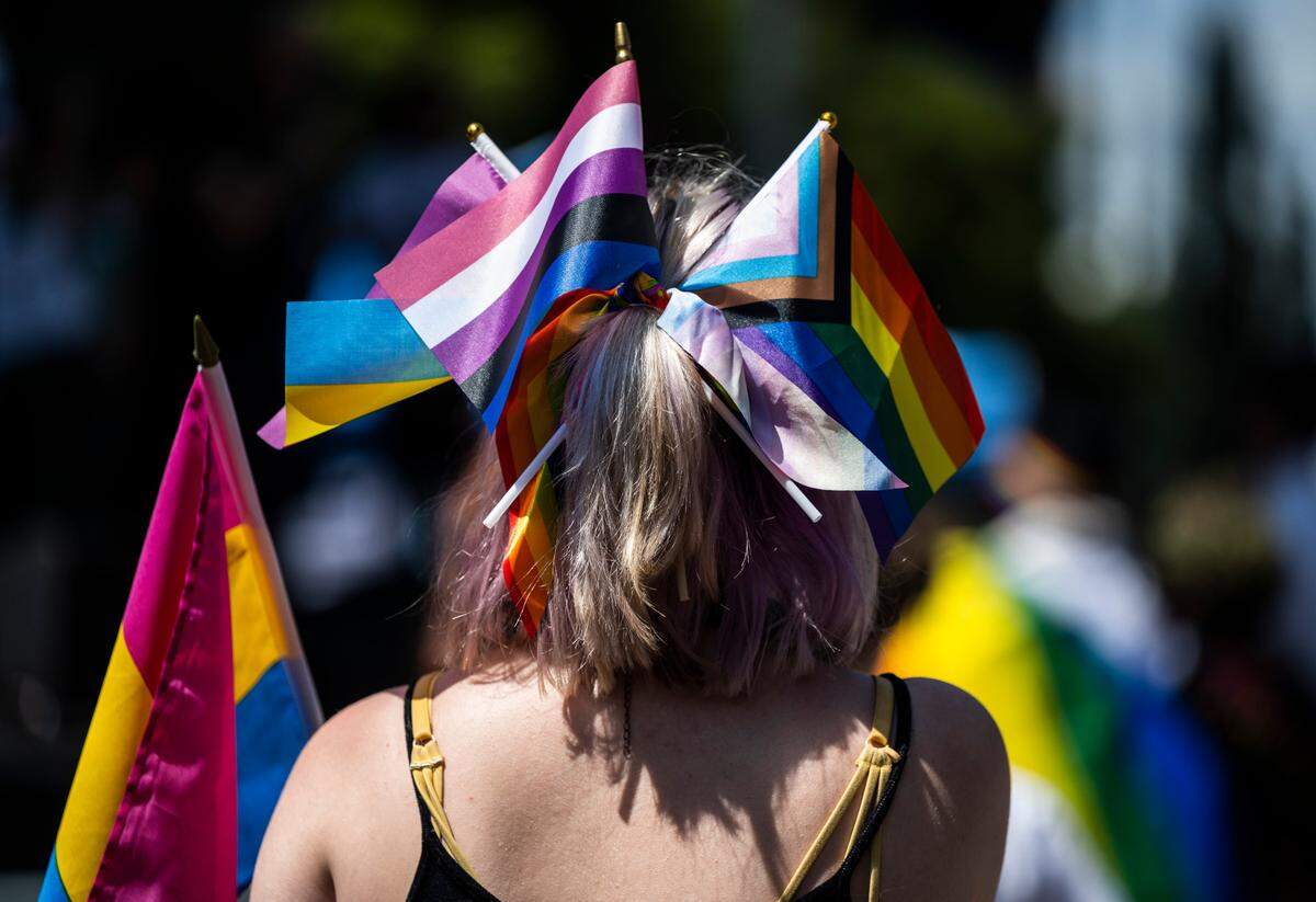 An LGBTQ Pride festival goer wears pride flags in their hair at the Tacoma Pride Festival on Pacific Avenue in Tacoma on July 9, 2022.