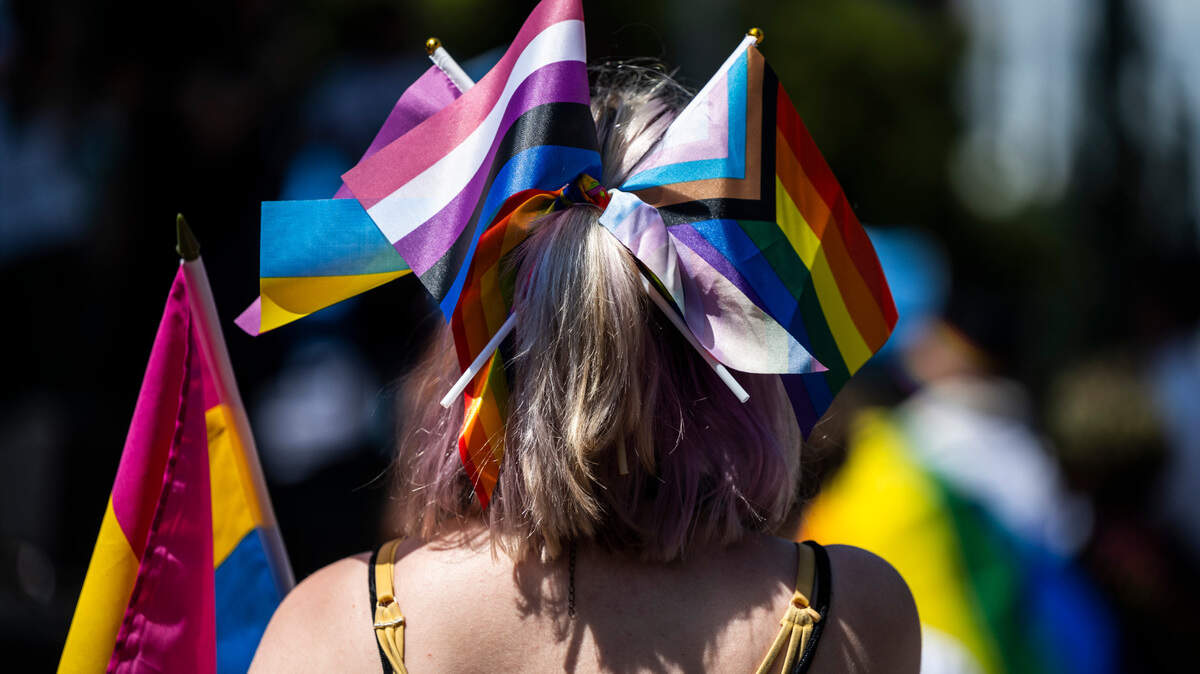 An LGBTQ Pride festival goer wears pride flags at the Tacoma Pride Festival on Pacific Avenue in Tacoma, Wash. on Saturday, July 9, 2022.