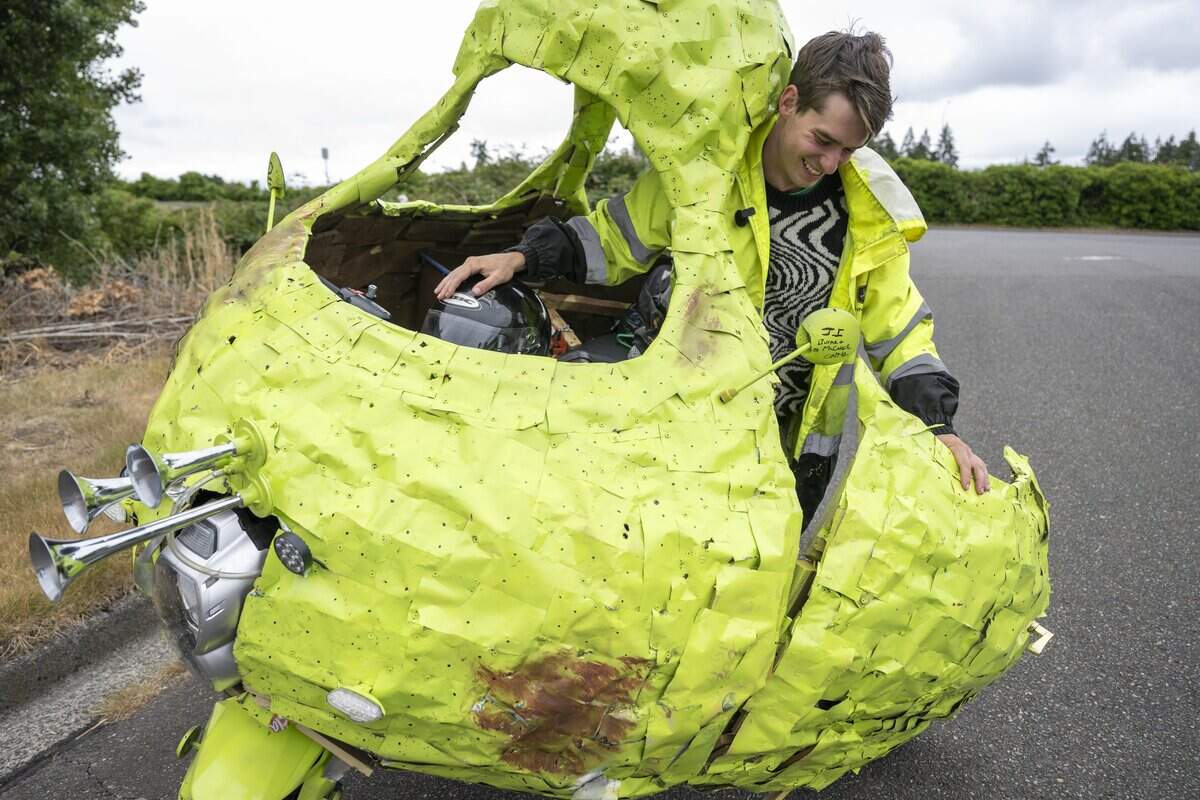 Andrew Glubbey steps out of the Pear Car, a sculpture built around the frame of a motorcycle, on Wednesday, July 8, 2026, in Tacoma, Wash.