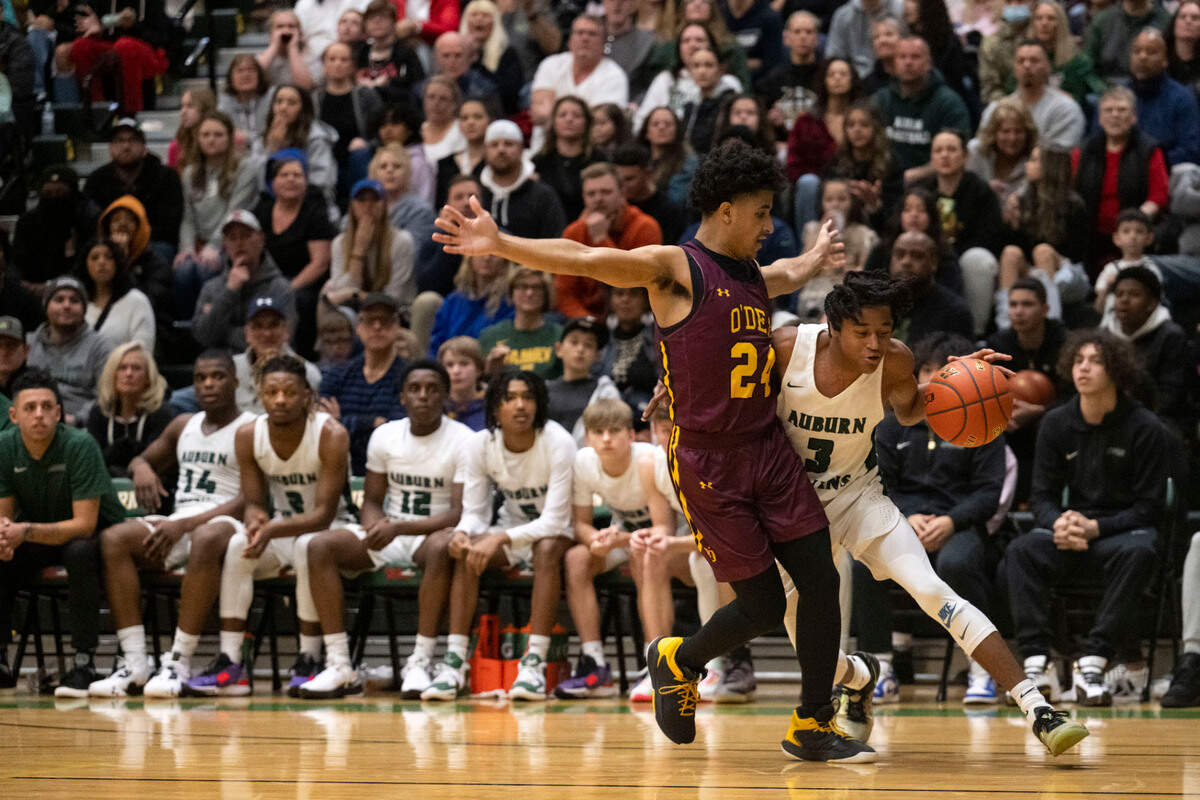 Auburn guard Tyrell Nichols (13) drives to the basket as O’Dea guard B.J. Shannon (24) defends during the third quarter of a Class 3A state regionals game on Saturday, Feb. 25, 2023, at Auburn High School in Auburn, Wash.