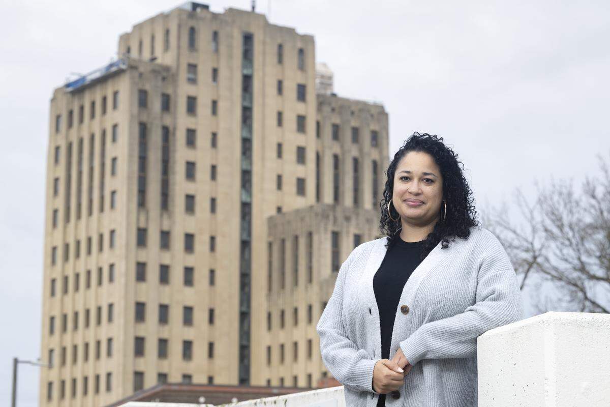Latasha Palmer, Tacoma's newly elected at-large City Council member, poses for a portrait with City Hall behind her on Wednesday, Dec. 3, 2025, in Tacoma, Wash.