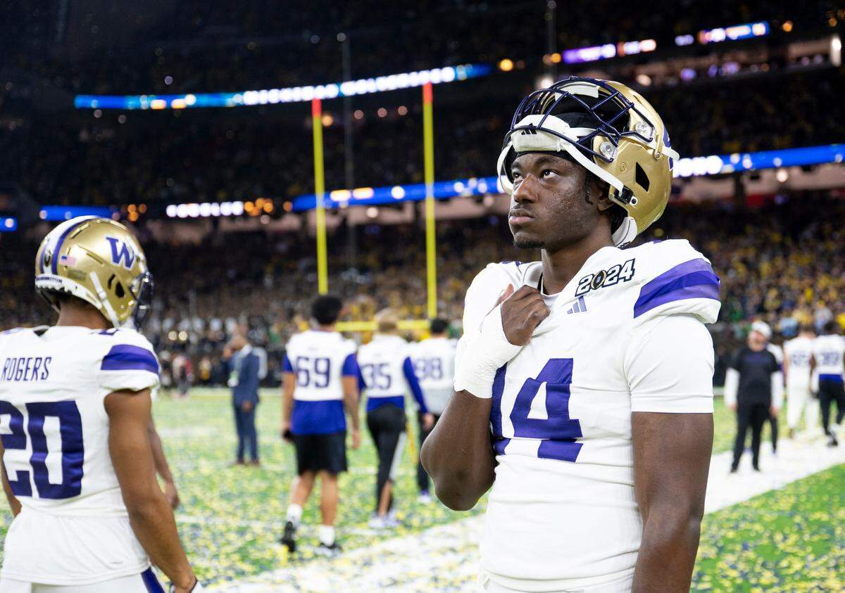 Washington Huskies defensive end Milton Hopkins Jr. (14) watches from the sidelines as Michigan celebrates after the Washington Huskies 34-13 lose to Michigan Wolverines in the College Football Playoff National Championship game at NRG Stadium on Monday, Jan. 8, 2024, in Houston.