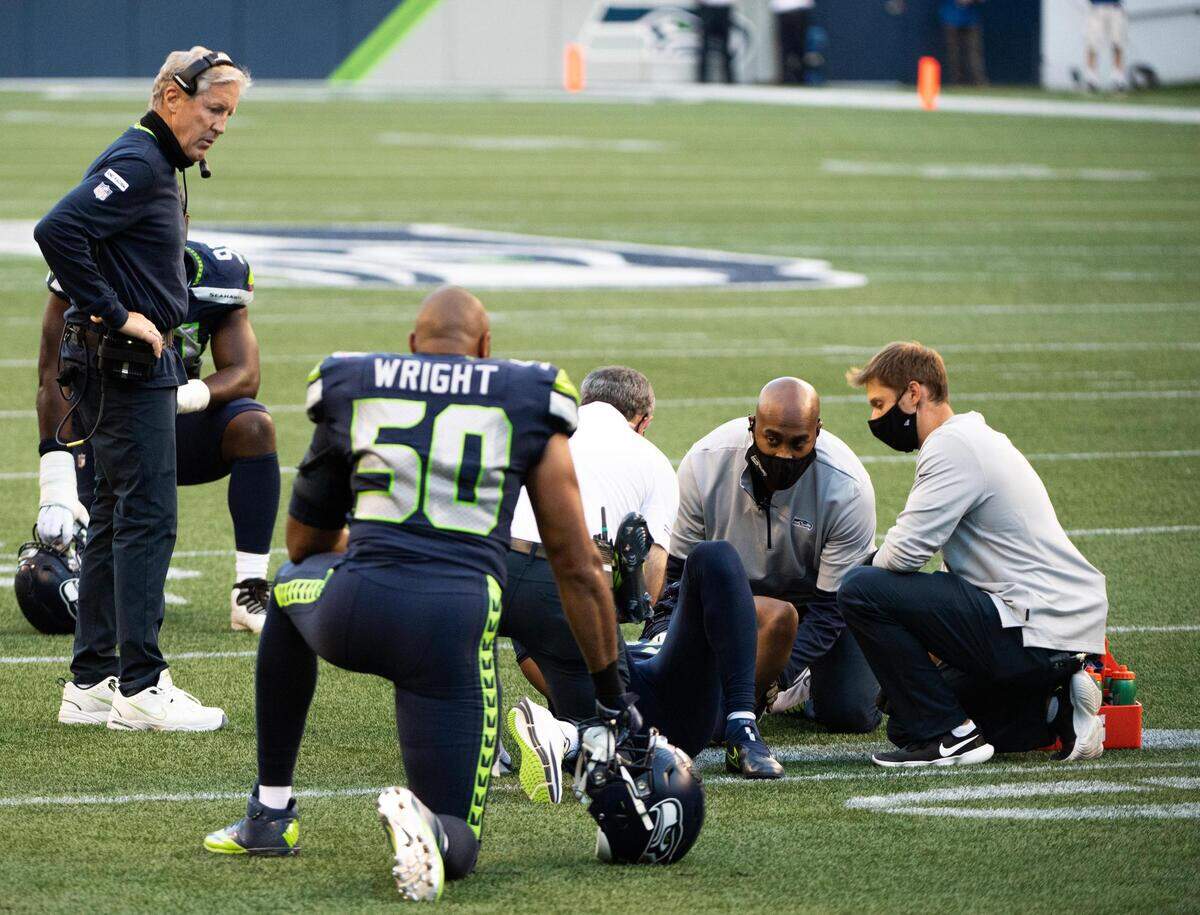 Seattle Seahawks head coach Pete Carroll watchers as medical staff look at Seattle Seahawks safety Marquise Blair (27) after Blair injured his leg. The Seattle Seahawks played the New England Patriots in a NFL football game at CenturyLink Field in Seattle, Wash., on Sunday, Sept. 20, 2020.