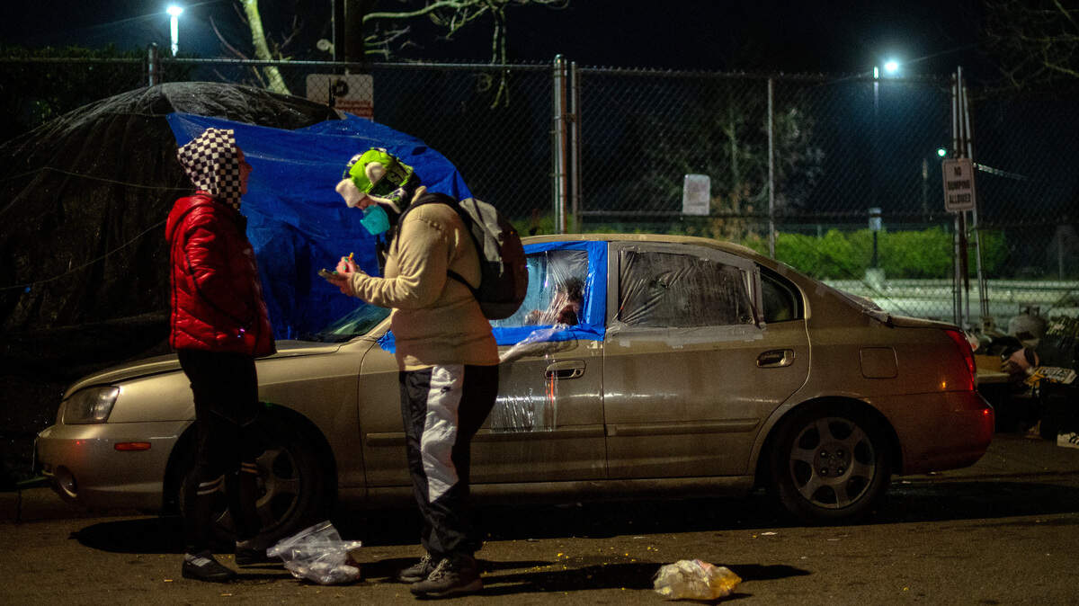 Sonja Nikiema, a Point in Time Count volunteer, talks with a person living out of their car on the side of East I Street in Tacoma on Jan. 27, 2022.