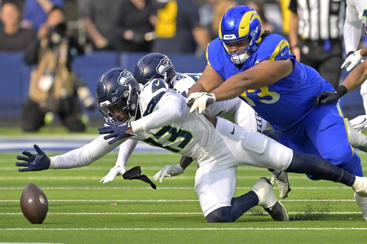 Jan 5, 2025; Inglewood, California, USA; Seattle Seahawks linebacker Ernest Jones IV (13) eats Los Angeles Rams guard Steve Avila (73) to the ball as he recovers a fumble in the first half at SoFi Stadium. Mandatory Credit: Jayne Kamin-Oncea-Imagn Images