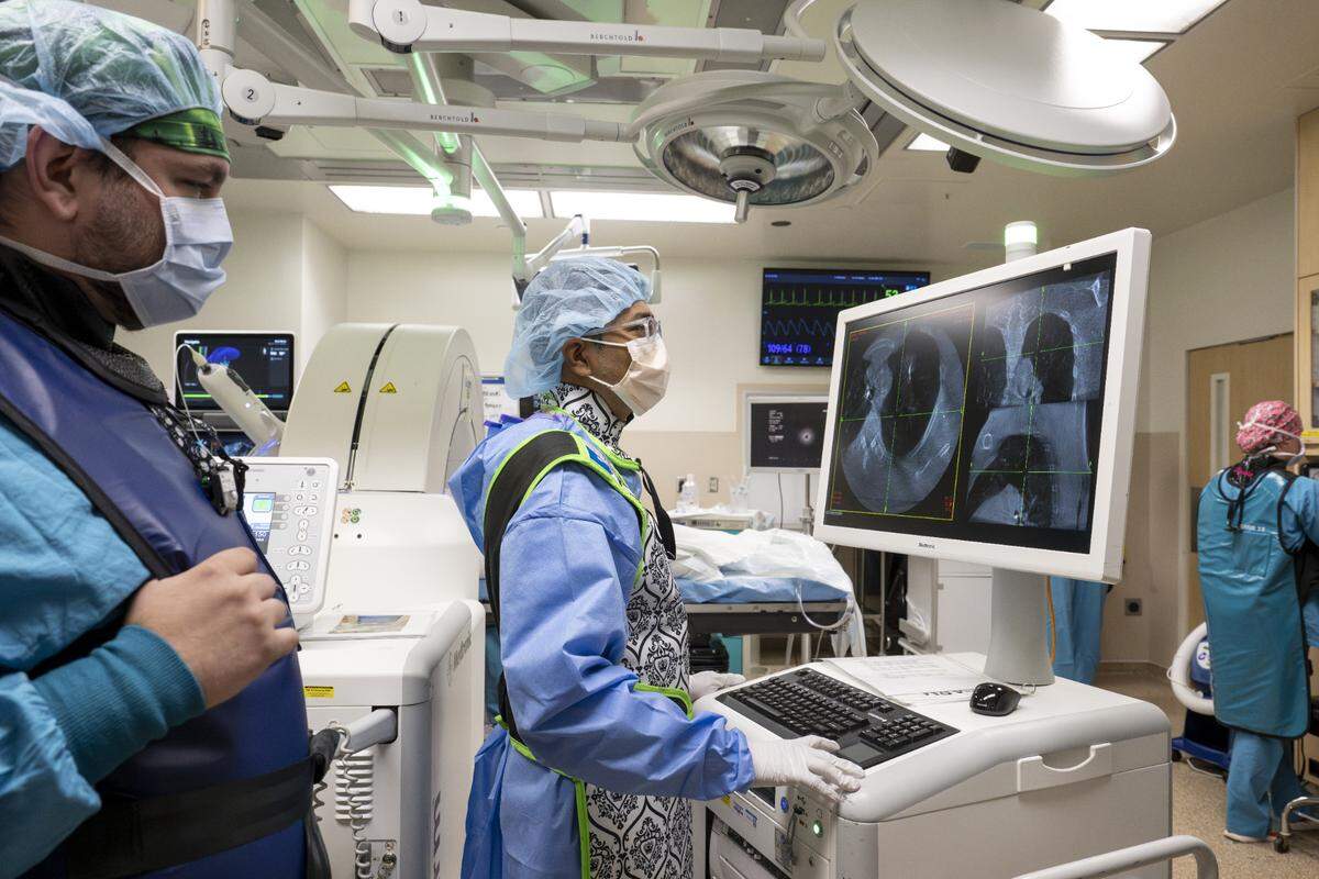 Further imaging is reviewed by Abhishek Biswas, center, a pulmonologist with Multicare Health, to confirm the needle on the DaVinci ION robotic surgery system is in the proper place to take a lung biopsy on Wednesday, May 21, 2025, at Good Samaritan Hospital in Puyallup, Wash.