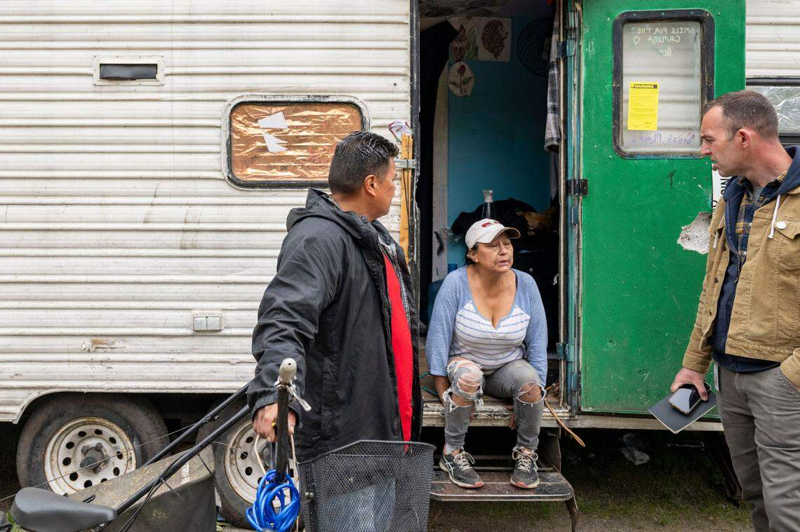 News Tribune opinion editor Matt Driscoll (right), listens as Lisa Zollner (center) talks about the difficulties surrounding her situation living in a trailer off South Tyler Street in Tacoma on May 30, 2023.