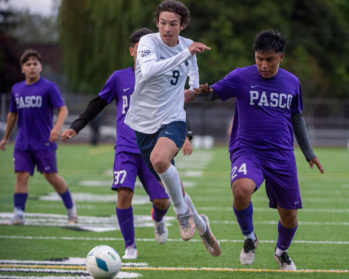 Bellarmine Prep’s Cael Tackett dribbles past Pasco’s Jayden Barajas (37) and Brian Martinez Ramirez (24) during the second half of a 4A semifinal game at Sparks Stadium on Friday, May 27, 2022, in Puyallup, Wash.