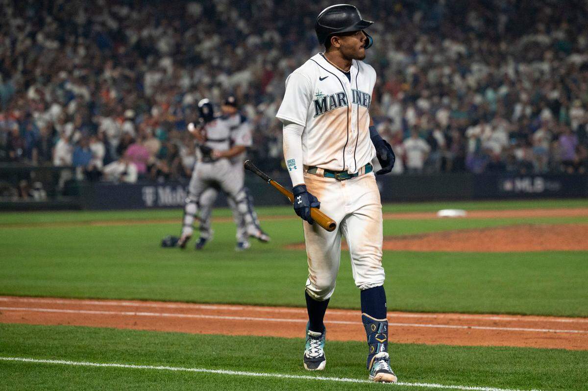 Houston Astros players celebrate as Seattle Mariners center fielder Julio Rodriguez (44) walks off the field after popping out to end the bottom of the 18th inning of game 3 of the ALDS on Saturday, Oct. 15, 2022, at T-Mobile Park in Seattle. Houston’s Jeremy Pena hit a solo home run in the top of the 18th inning to earn the Astros a sweep of the Mariners in the American League Divisional Series.