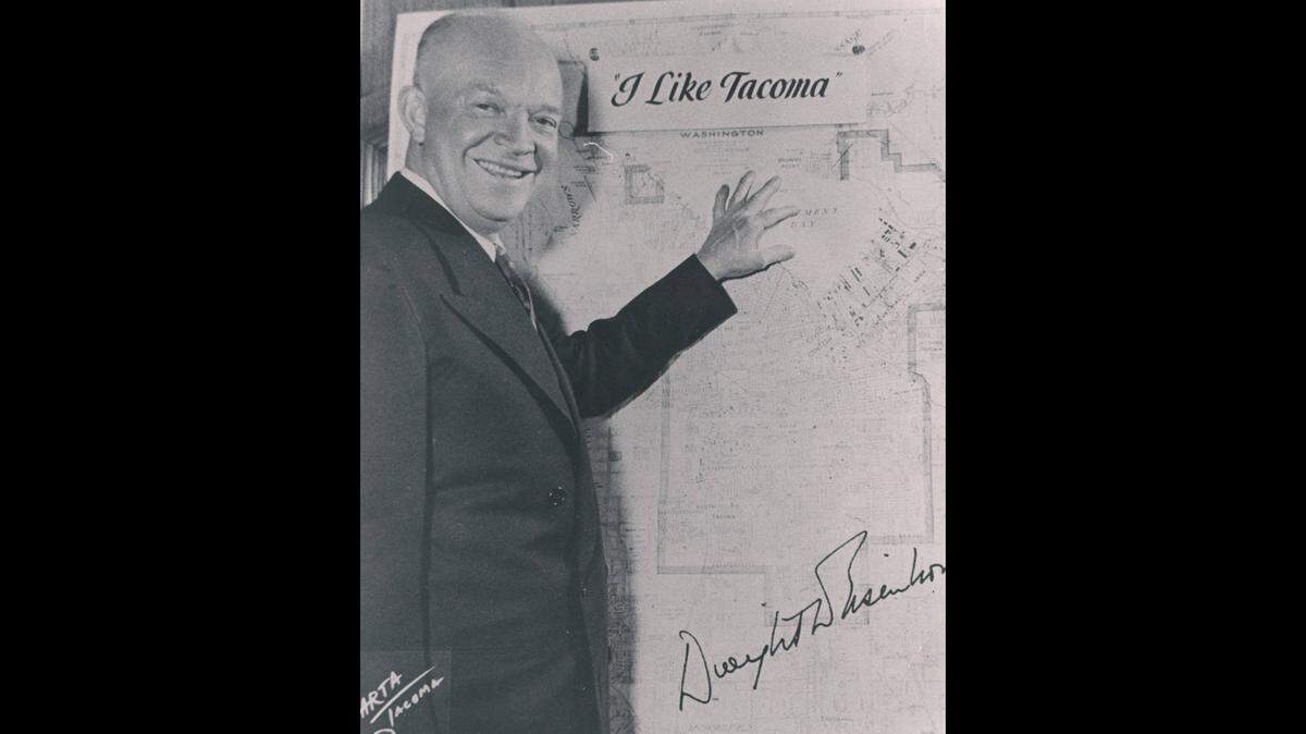 Undated autographed photograph of Dwight D. Eisenhower standing before a map of Tacoma. The famous slogan “I Like Ike” has been modified to read “I Like Tacoma” and is placed over portions of the map.