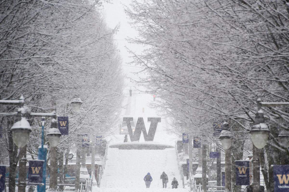 The University of Washington Tacoma offers support to formerly incarcerated students through its Husky Post-Prison Pipeline project. In this photo, people make their way up the steps at UWT campus as snow falls in Tacoma, Wash., on Saturday, Feb. 13, 2021.